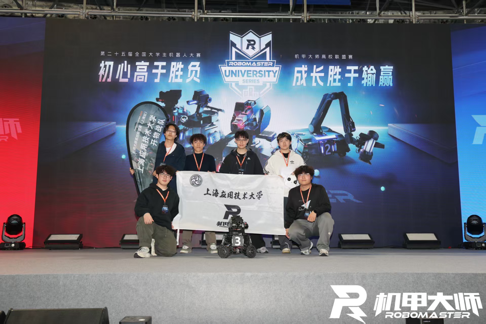 开物队员持队旗在 RoboMaster 高校联盟赛现场合影